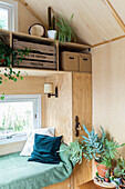 Small living room with wooden walls, seating area and plants