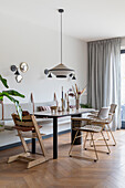 Dining room with metal chairs, modern pendant lamp and wooden floor