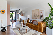 Open-plan living area with brown velvet sofa and organically shaped coffee table