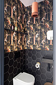 Stylish guest WC with black hexagon tiles and jungle wallpaper