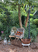 Garden arrangement with rattan and metal baskets, clay pots and glass bottles