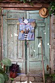 Garden tools in patterned fabric organiser on antique wooden door