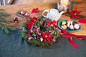 Christmas table wreath with red poinsettias (Euphorbia pulcherrima)