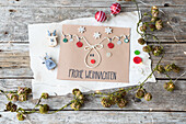 Christmas greeting card with reindeer decoration and "Merry Christmas" lettering on a wooden table