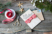 Christmas craft scene with greetings card, ribbon and scissors on a wooden table