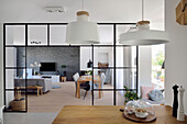 Open-plan living area with modern pendant lights and glass room divider