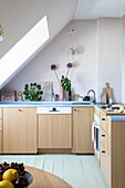 Bright attic kitchen with skylight and wooden elements