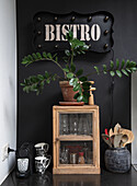 Kitchen area with small wooden display cabinet, coffee machine and illuminated sign