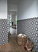 Patterned wall tiles in hallway with wooden floor and basket