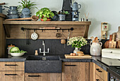 Country kitchen with dark sink and wooden cupboards