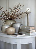 Decoration of pottery and books on a white side table