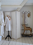 Dressing room with white screen and antique rocking horse