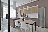 Modern kitchen with dining table and floral decorations in Warsaw flat