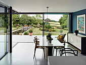 Dining area with garden view through floor-to-ceiling glazing, Hertfordshire, UK
