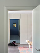 View through the hallway with dogs into the house with modern furnishings