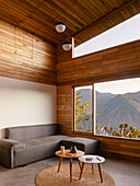 Living room with high ceiling, panoramic windows and wood paneling
