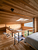 Gallery with sleeping and reading area, wood panelling and skylight