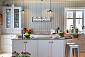 Country kitchen with kitchen island, bar stools and plate rack