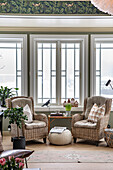 Rattan armchair, side table and pouf by the window