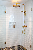 Shower with golden rain shower and white metro tiles