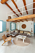 Living room with exposed wooden beams, blue shutters, cosy seating area and gallery