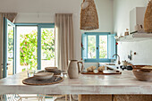 Kitchen with counter, blue shutters and rattan lamps