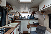 Cosy living area in a van with built-in kitchenette and sleeping area