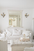 Living room with white sofa, mirror and crystal chandeliers on the wall