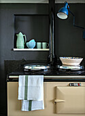 Vintage kitchen cooker, cups, jug and bowls in a wall niche