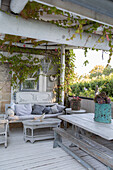 Covered terrace with vintage and rattan furniture and plant tendrils