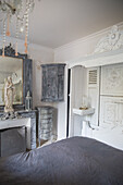 Baroque bedroom with antique furniture in grey tones and statue of the Virgin Mary on the mantelpiece