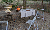 Rustic, laid garden table with pumpkin and linen cloth