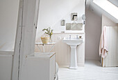 Bright bathroom with sloping ceiling and pillar washbasin