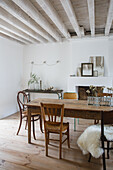 Dining room with rustic wooden table, various wooden chairs and wooden beamed ceiling