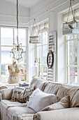 Bright living room with hanging birdcages, chandelier and dressmaker's dummy