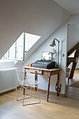 Antique wooden desk with metal chair in the attic area