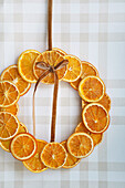 DIY door wreath made from dried orange slices on a chequered background