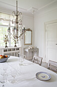 Dining room with chandelier and antique furniture in white