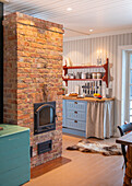 Open-plan country-style kitchen with brick wall and fireplace