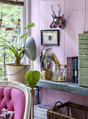 Decorative shelf with plants and books in a pastel pink room