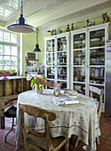 Kitchen with rustic dining table and display cabinets full of books and crockery