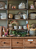 Country-style wooden shelf with porcelain dishes and Christmas decorations