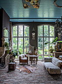 Living room with high windows, antique furniture and blue-painted ceiling