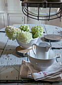 Hydrangea in a white bowl on a rustic wooden table