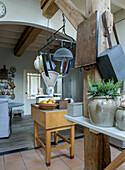 Farmhouse kitchen with wooden beams, hanging rack and kitchen island block