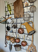 Kitchen wall bracket with copper pots, sieves and various kitchen utensils