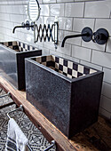 Double stone washbasin with chequerboard pattern inside and metro tiles on the wall