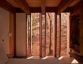 Schlafzimmer mit Holzbalkendecke und Blick in die Natur