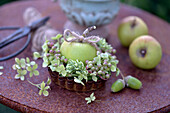 Decoration of hydrangea flowers, sedum, apple and acorns in a baking tin