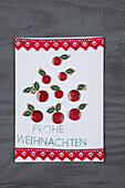 Handmade Christmas card with buttons and lace ribbon on a grey wooden background